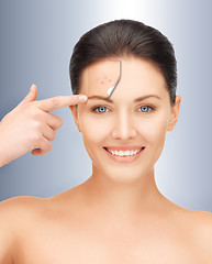 Image showing beautiful woman pointing to forehead