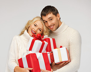 Image showing romantic couple in a sweaters with gift boxes