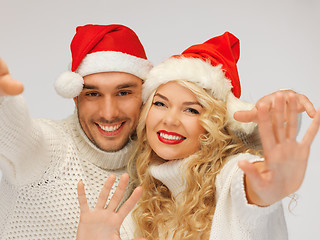 Image showing family couple in sweaters and santa's hats