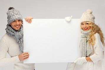 Image showing couple in a winter clothes holding blank board