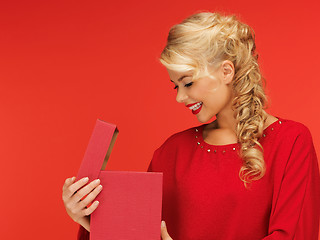 Image showing lovely woman in red dress with opened gift box