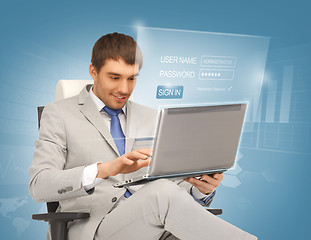 Image showing young businessman sitting in chair with laptop