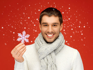 Image showing man in warm sweater and scarf with snowflake