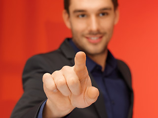 Image showing handsome man in suit pressing virtual button