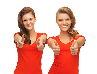 Image showing wo teenage girls in red t-shirts showing thumbs up