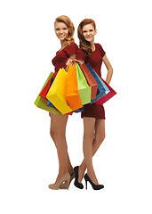 Image showing teenage girls in red dresses with shopping bags