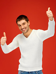 Image showing man in warm sweater showing thumbs up