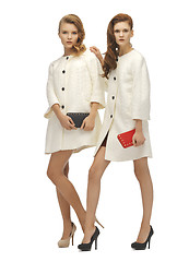 Image showing two teenage girls in white coats with clutches