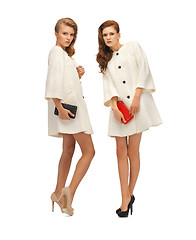 Image showing two teenage girls in white coats with clutches