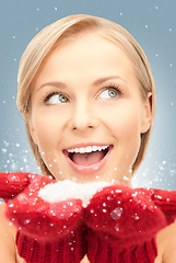 Image showing beautiful woman in red mittens with snow