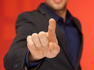 Image showing handsome man in suit pressing virtual button