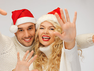 Image showing family couple in sweaters and santa's hats