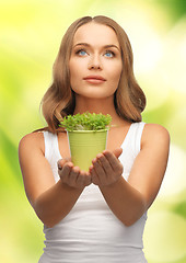 Image showing woman with green grass in pot