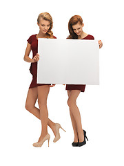 Image showing two teenage girls in red dresses with blank board