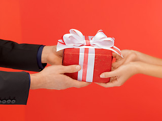 Image showing man and woman's hands with gift box