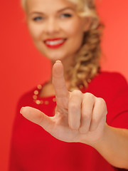 Image showing woman in red dress pressing virtual button