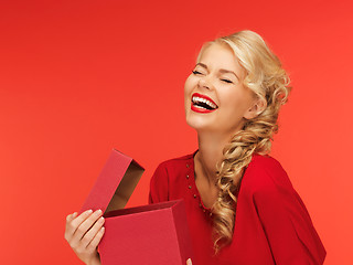 Image showing lovely woman in red dress with opened gift box