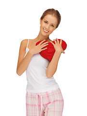 Image showing happy and smiling woman with heart-shaped pillow