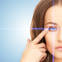 Image showing beautiful woman pointing to eye