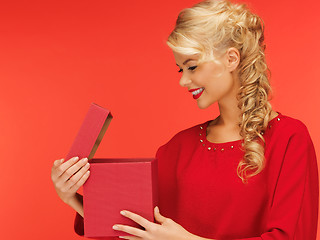 Image showing lovely woman in red dress with opened gift box