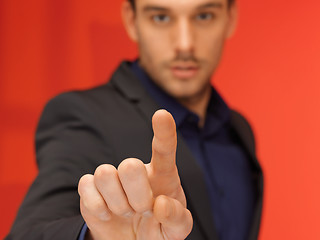 Image showing handsome man in suit pressing virtual button