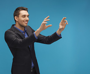 Image showing man in suit working with something imaginary