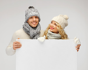 Image showing couple in a winter clothes holding blank board