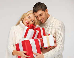 Image showing romantic couple in a sweaters with gift boxes