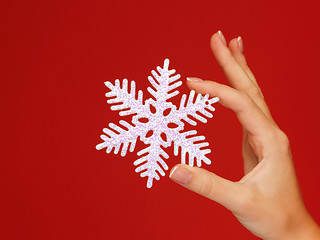 Image showing woman's hands holding a snowflake