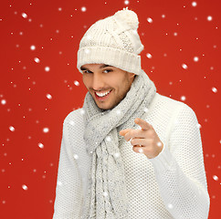 Image showing handsome man pointing his finger with snow