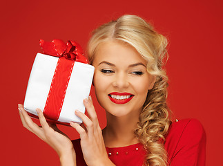 Image showing lovely woman in red dress with present