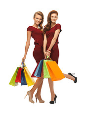 Image showing teenage girls in red dresses with shopping bags