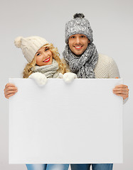 Image showing couple in a winter clothes holding blank board