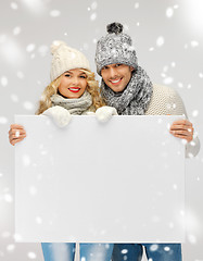 Image showing couple in a winter clothes holding blank board