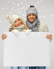 Image showing couple in a winter clothes holding blank board