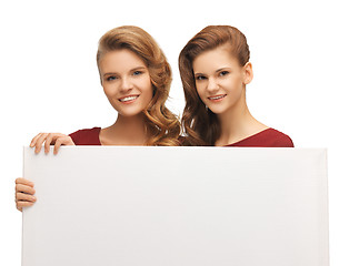 Image showing two teenage girls in red dresses with blank board