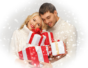 Image showing romantic couple in a sweaters with gift boxes