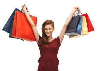 Image showing teenage girl in red dress with shopping bags