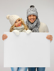 Image showing couple in a winter clothes holding blank board