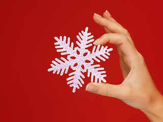 Image showing woman's hands holding a snowflake