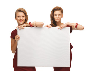 Image showing two teenage girls in red dresses with blank board