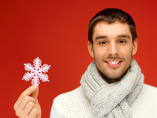 Image showing man in warm sweater and scarf with snowflake