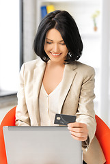 Image showing happy woman with laptop computer and credit card