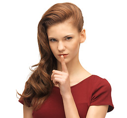 Image showing teenage girl in red dress with finger on lips