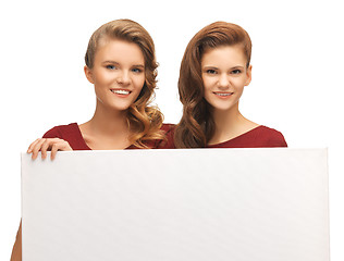 Image showing two teenage girls in red dresses with blank board