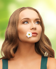 Image showing woman with camomile in mouth