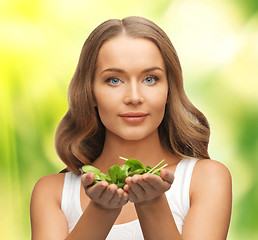 Image showing woman with spinach leaves on palms