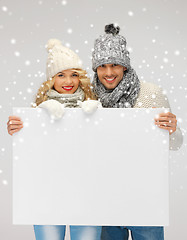 Image showing couple in a winter clothes holding blank board