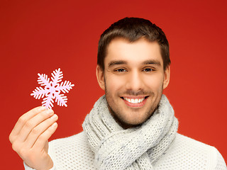 Image showing man in warm sweater and scarf with snowflake