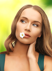 Image showing woman with camomile in mouth